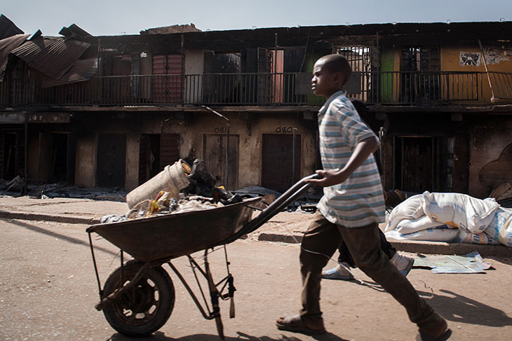 The conflict has displaced hundreds of thousands of people from the northeast. This photo shows a boy salvaging what is left of homes and businesses after a crisis in Jos, Nigeria, in 2010, which left over 500 people dead and thousands displaced and homeless. © 2010 Ruth McDowall.
