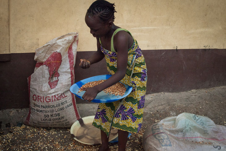 A child orphaned by the conflict in northern Nigeria prepares food in her new home outside of the conflict states. © 2014 Watchlist/Ruth McDowall.